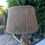 Miniature : Lampe en corde tressée, abat-jour marron clair, support en bois et arrière-plan flou.