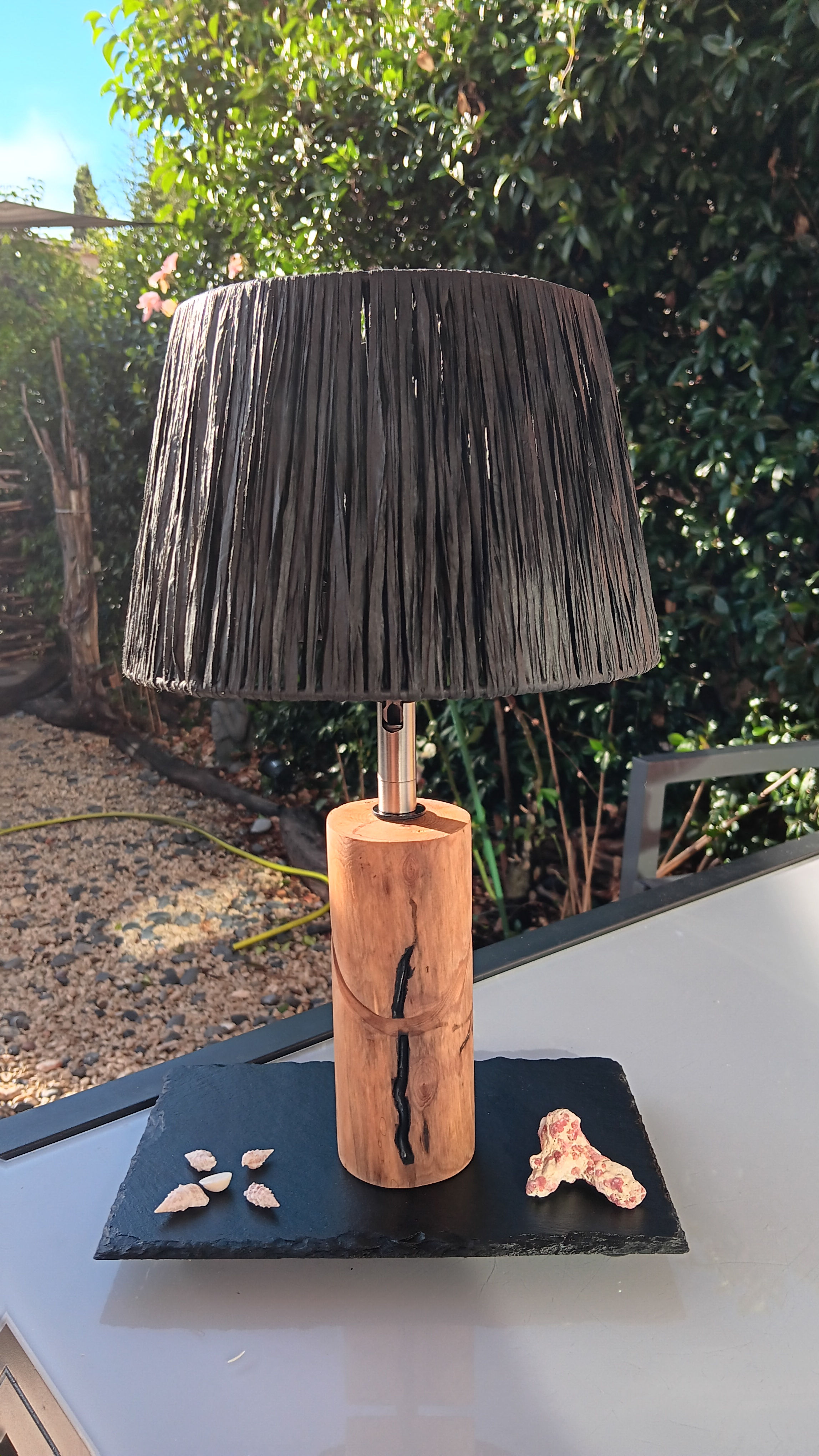 Lampe en bois avec abat-jour noir. Vue de près, sur une table en bois.