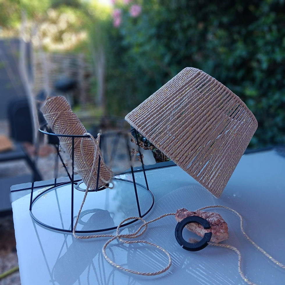 Lampe avec abat-jour, fil, anneau, et structure en métal sur fond vert.