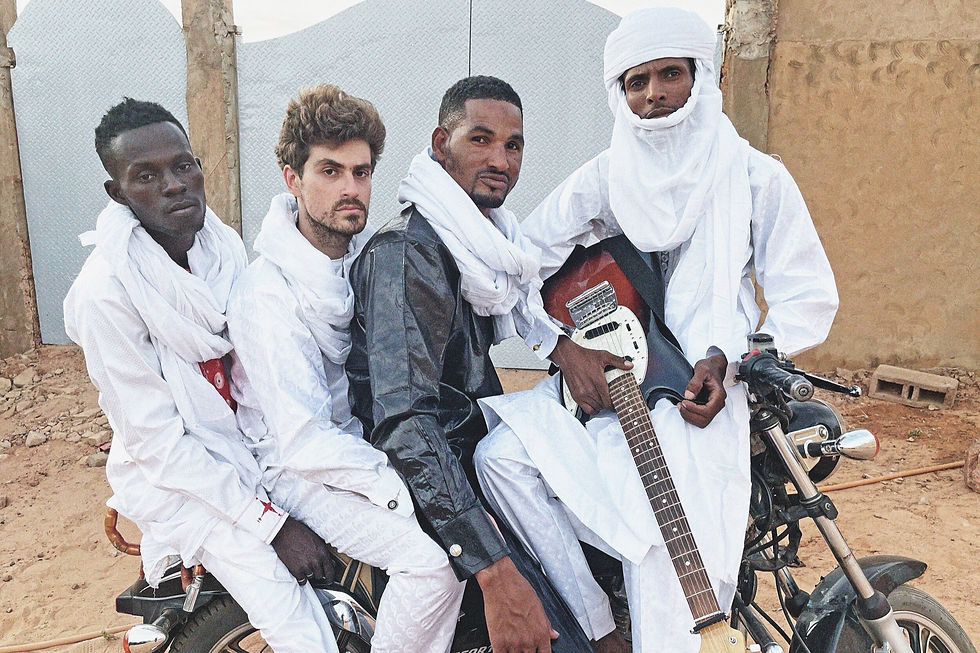 Quatro integrantes da banda sentados em uma moto