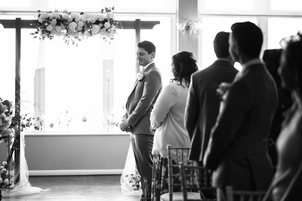 The groom reacts emotionally to seeing the bride walk down the aisle during their wedding at the St Ives Harbour Hotel