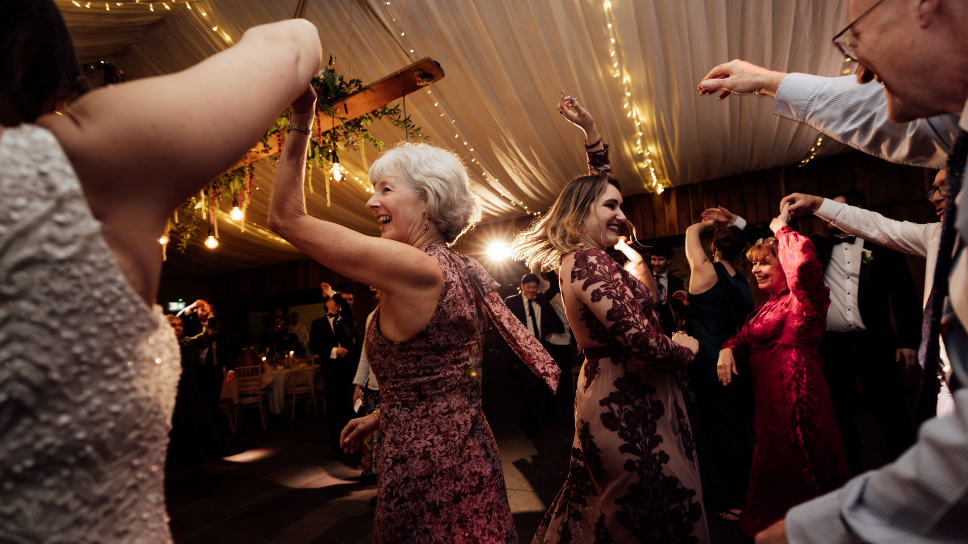 Guests dance in warm light during a wedding reception at Trevenna Farm in Devon.
