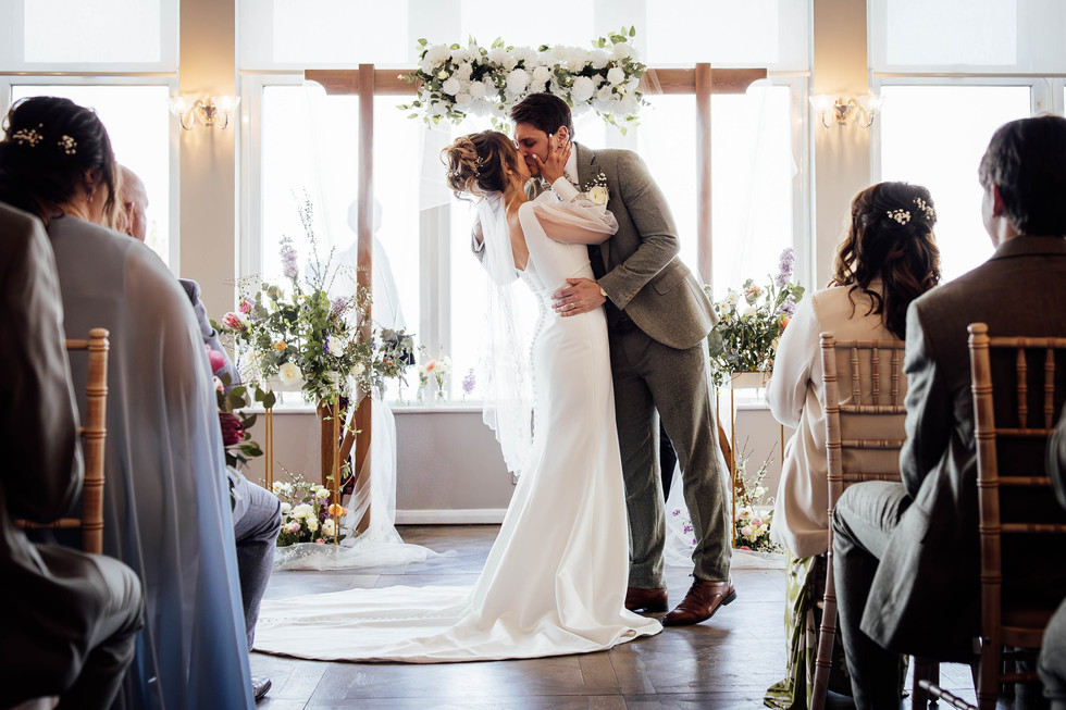 A bride and groom share their first kiss during their wedding at the St Ives Harbour Hotel in Cornwall, photographed by Fox and Co Photography. 