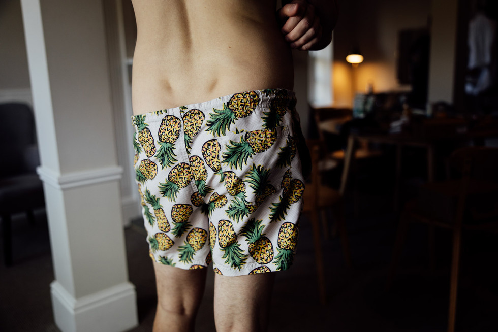 The groom stands in flamboyant pineapple boxer shorts prior to his wedding in Syrencot. 
