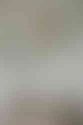 Lace wedding dress hanging in the window of a quaint Cornish cottage