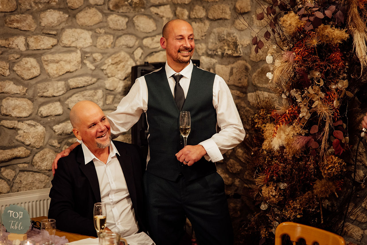 The groom and his family member laugh and hug