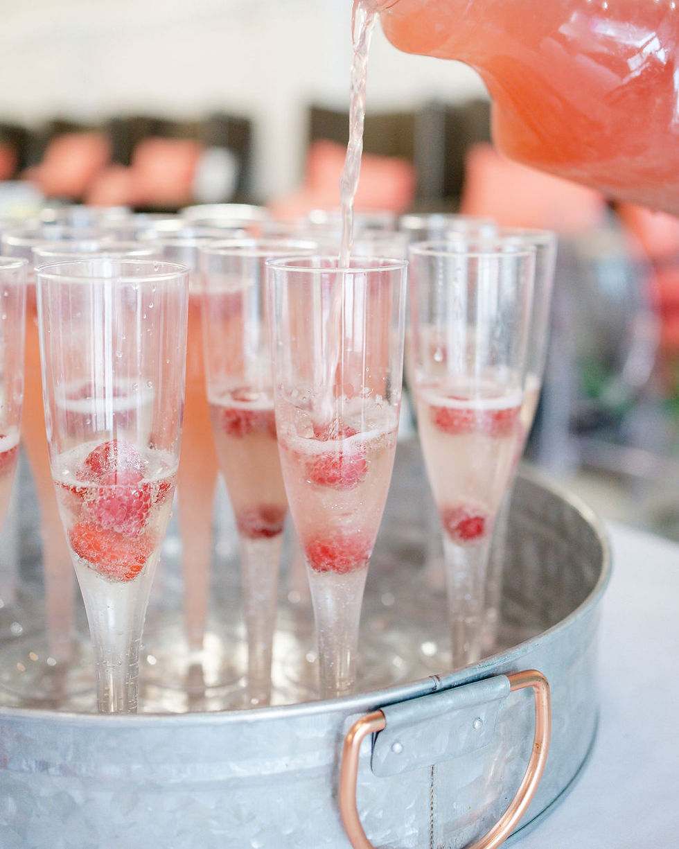 several champagne glasses of mimoas with strawberries on a tray