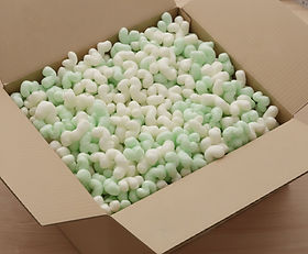 Offener Karton mit grünen Stärke-Chips – Bio Füllmaterial.