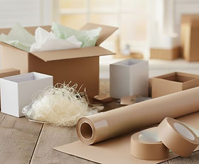 Seidenpapier, Karton und Papierklebeband auf Tisch – plastikfrei verpackt.