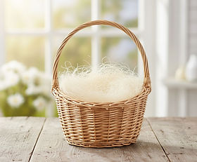 Korb mit Sisalwolle und Papierwatte auf Holztisch – nachhaltige Füllung.