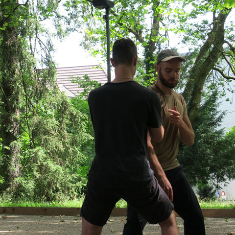 Zwei Männer üben Tai-Chi im Park