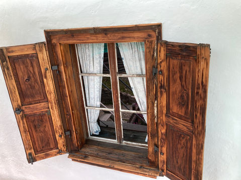 Rustikales Holzfenster der Chesa Cabalzar mit Fensterläden
