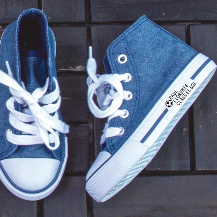 Miniatura: Marcador Mine estampando nombre en unas zapatillas de lona.