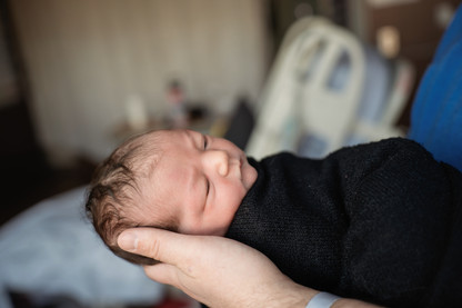 Des Moines, Iowa Fresh 48 Photography - Dad holds his newborn daughter in his arms with her eyes open.