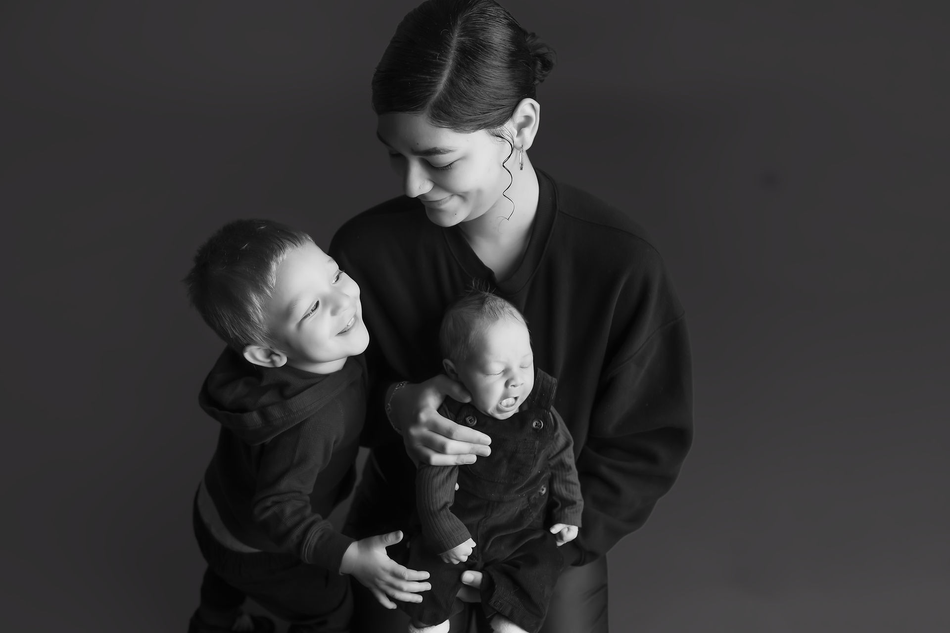 Des Moines newborn photographer, black and white image of a mother with toddler and newborn sons 