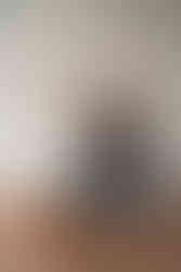 Des Moines, Iowa teen and children's photography - teen girl with long dark hair is sitting on a wooden floor surrounded by red rose petals while toddler brother climbs in her lap.