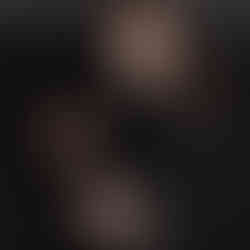 Des Moines, Iowa newborn photographer - New mother holding her infant son swaddled in a black cloth on a black background