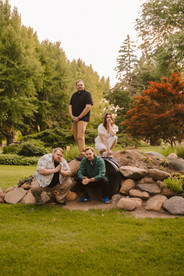 Norwalk and Des Moines, Iowa family photographer - adult siblings pose in a natural playscape in an 'album cover' pose looking tough.