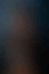 Des Moines and Norwalk, Iowa photography - woman with dark hair a colorful flannel poses against blue backdrop with a guitar under her chin.