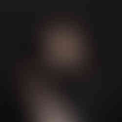 Des Moines, Iowa newborn photographer - New mother holding her infant son swaddled in a black cloth on a black background