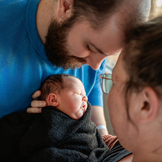 Des Moines, Iowa Fresh 48 Photography - parents hold their newborn daughter between them.