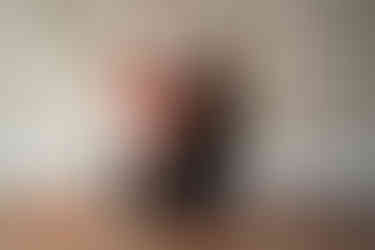 Des Moines, Iowa family photography - mother and baby sitting on a wooden floor surrounded by red rose petals and vintage Valentine's Day cards.