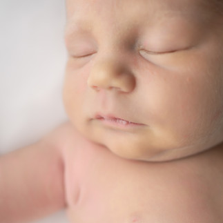Des Moines newborn photographer - macro shot of a newborn's facial features taken on a white backdrop.