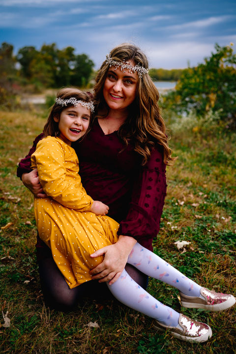 Des Moines, Iowa family photographer - mother holds her school-aged daughter outside.
