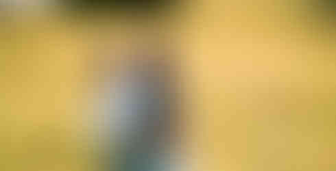 Des Moines, Iowa Family Photographer - a mother and her two daughters are hugging while standing in a prairie during golden hour.