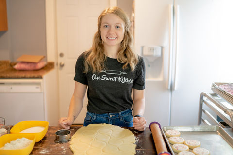 Des Moines, Iowa professional branding photographer - baking prepares her rolling pin by flouring it before rolling out sugar cookie dough and smiling