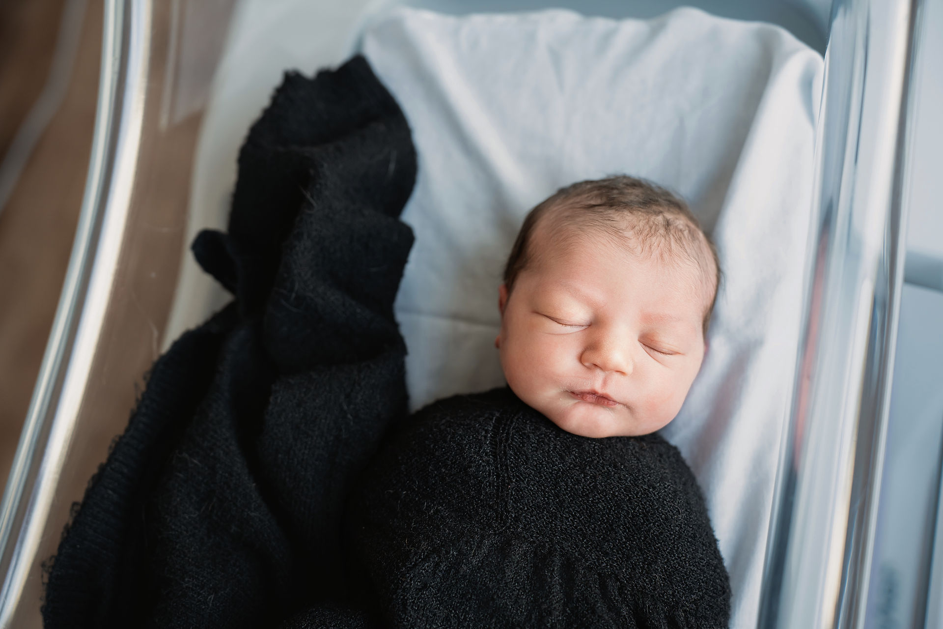 Des Moines, Iowa Fresh 48 Photographer - newborn baby girl swaddled in a black knit swaddle in her hospital bassinet