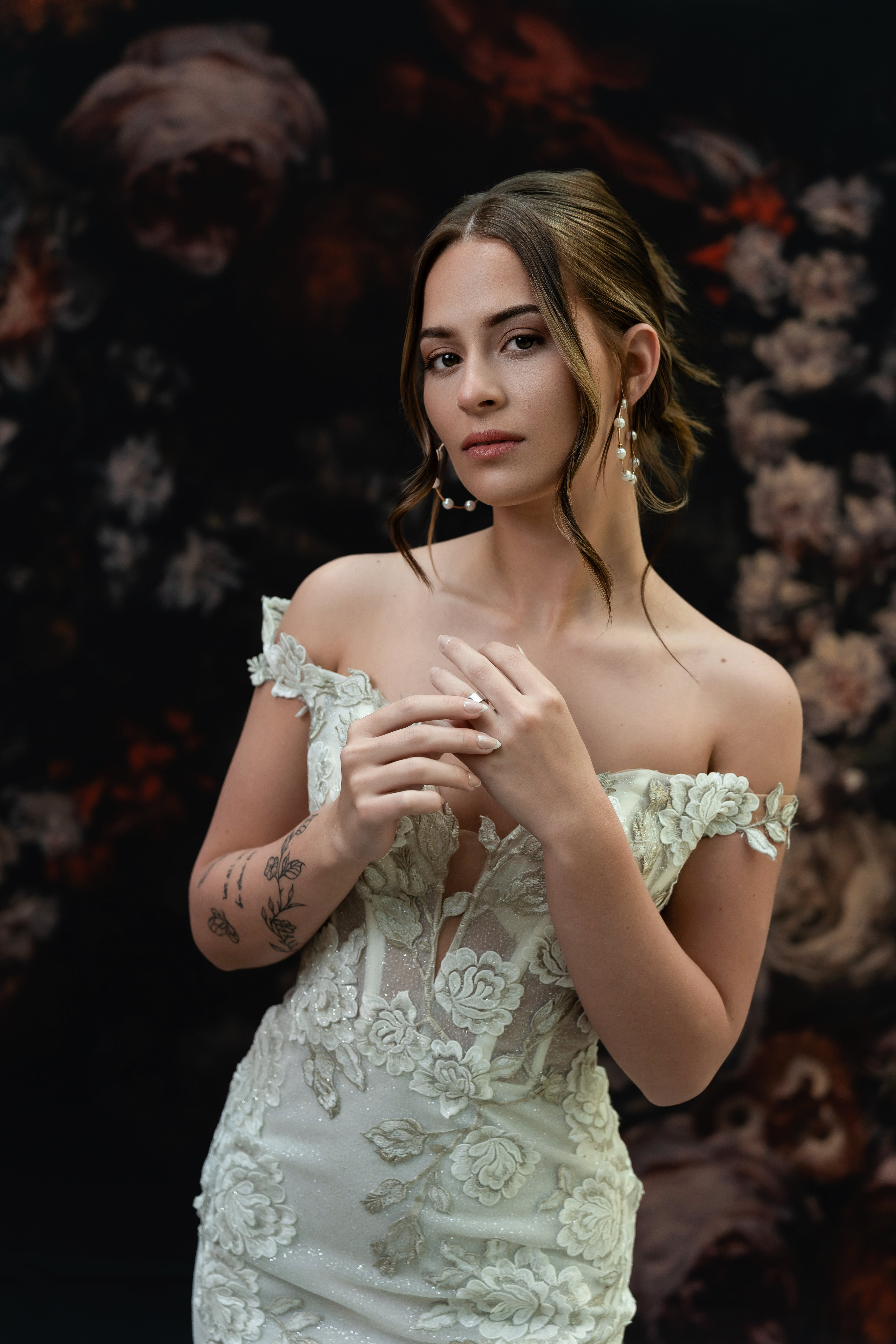Des Moines, Iowa glamour and boudoir photographer - woman in a off-white evening gown is photographed on a floral backdrop.