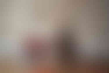 Des Moines, Iowa children and family photography - toddler boy with blonde curly hair is sitting inside a red metal wagon surrounded by red rose petals.