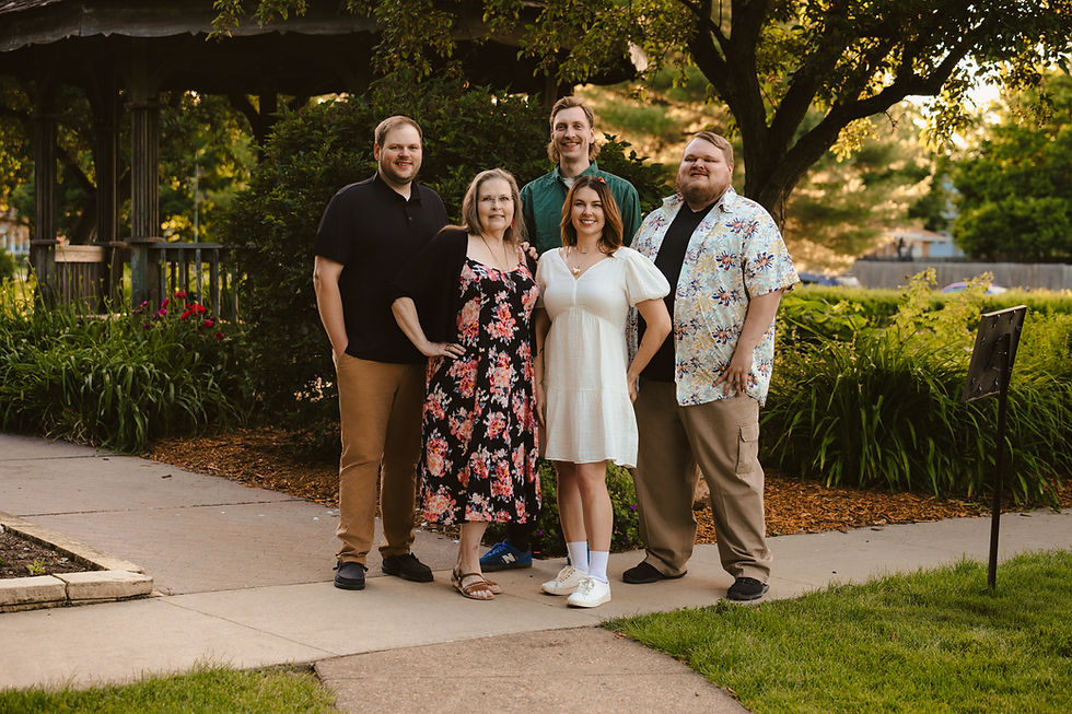 Norwalk and Des Moines, Iowa Family photographer - Adult woman in a floral dresses with four of her adult children-Three males and one female.