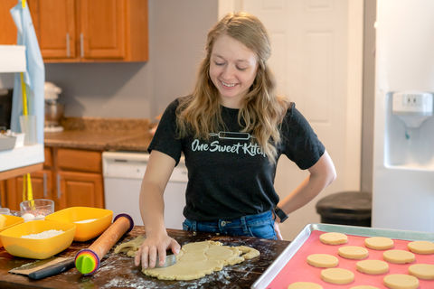 Des Moines and Norwalk, Iowa professional branding photographer - baker is pressing out rolled sugar cookies.