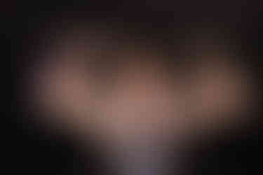 Norwalk and Des Moines, Iowa high school senior photography - high school wrestler flexing his biceps in the wrestling room.