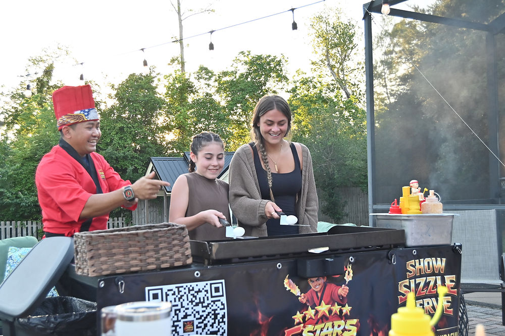 2 girls helping hibachi chef cook