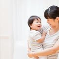 子供を抱く母親。自由でストレスフリーな起業や仕事、働き方をサポートするワイズカラーなので、母子写真を用いた。