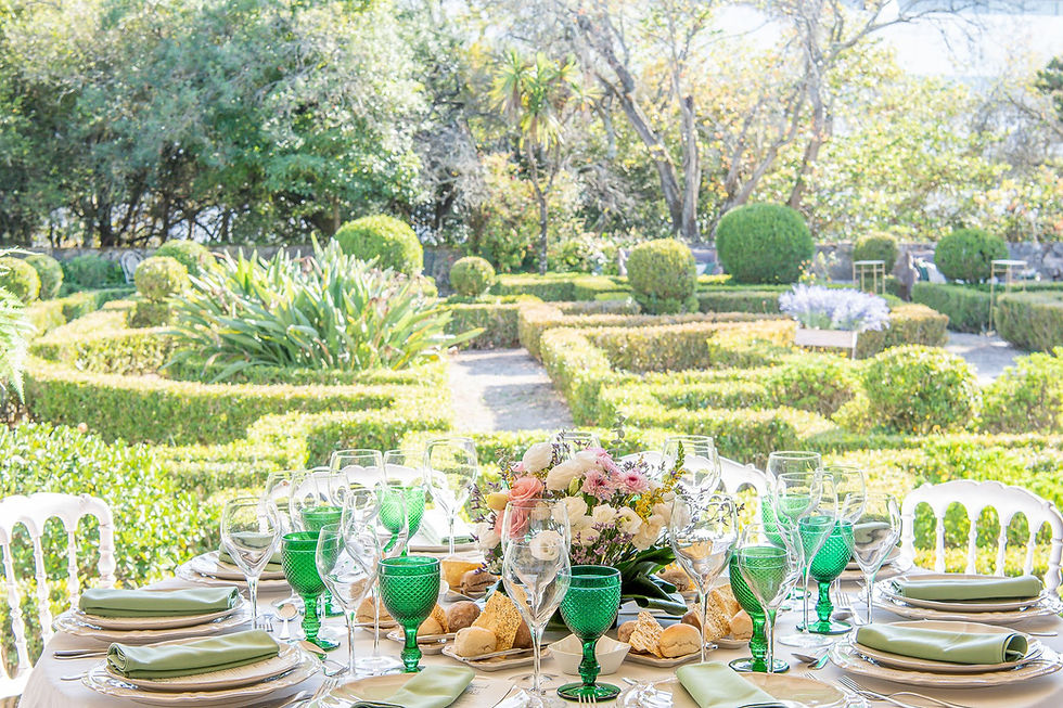 Um jantar de recepção de casamento no terraço coberto e vista para jardim francês da Quinta do Torneiro