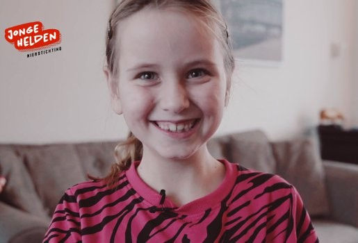 Jong meisje kijkt lachend in de camera