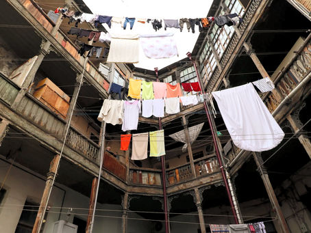 Kolorowe ubrania rozwieszone na sznurach nad dziedzińcami, balkonami i uliczkami w Kaukazie i Turcji, ukazujące lokalny rytuał wieszania prania, społeczny kodeks i estetykę codziennego życia.