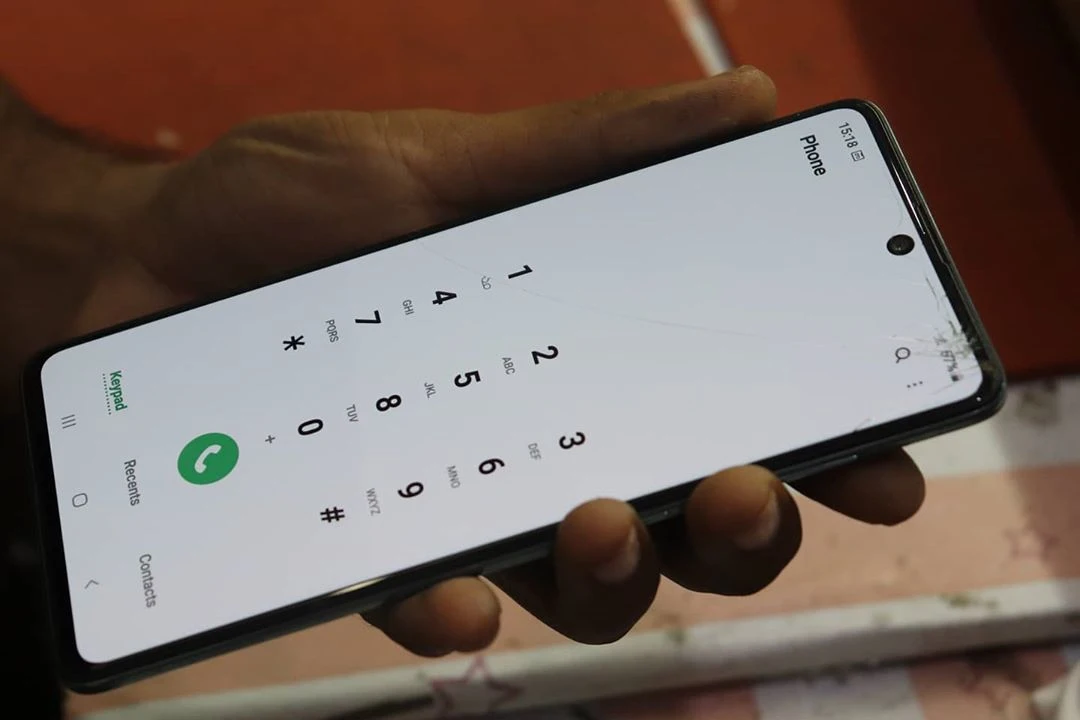 Hand holding phone showing dialer
