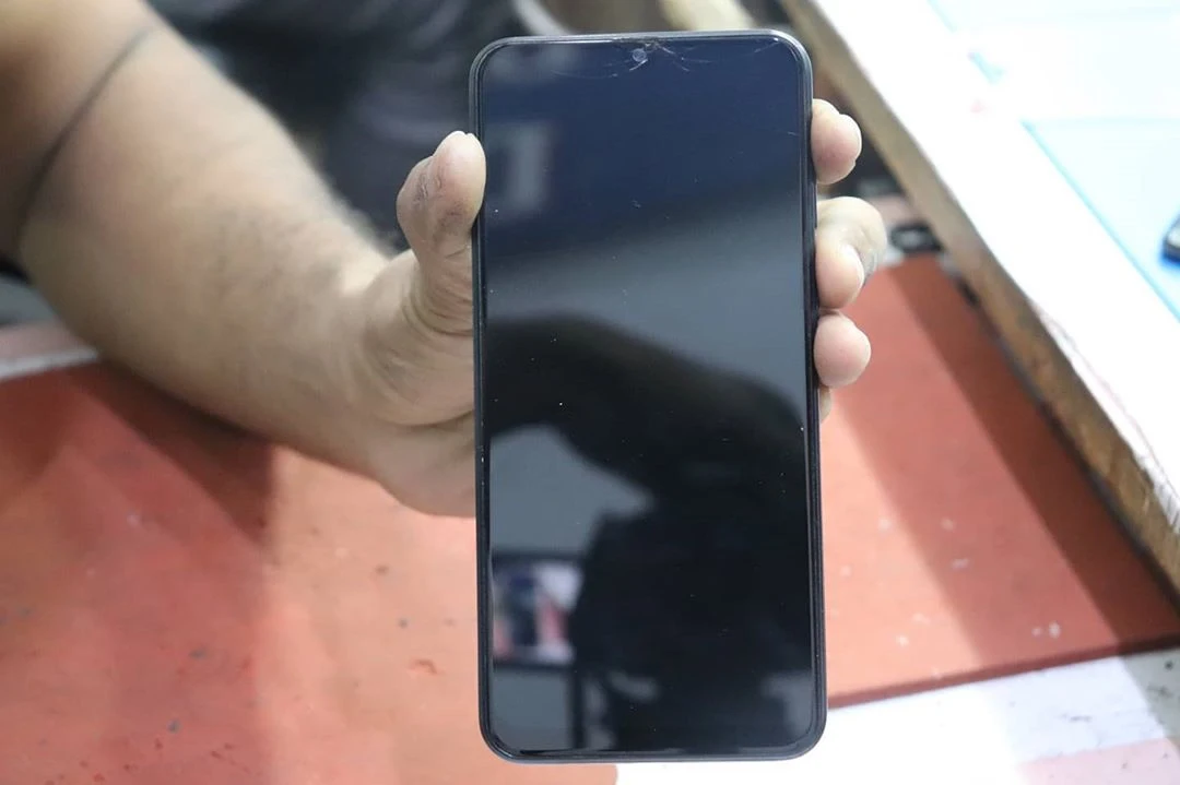 Hand holding a new phone screen replacement