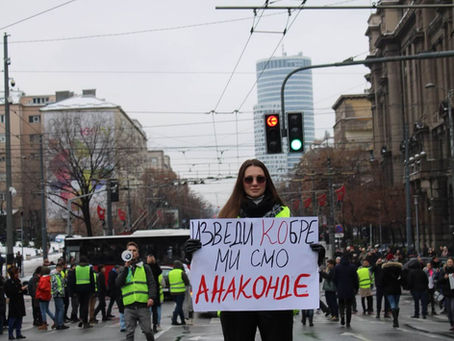 A protestor stands with a placard in front of a crowd