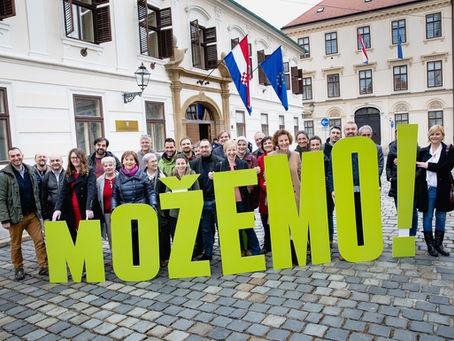 A group of party activists stand behind big letters spelling out MOZEMO in Zagreb