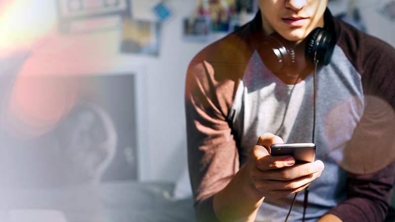 Young man using his phone in a room 