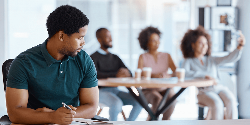 lonely male worker sitting apart from his coworkers