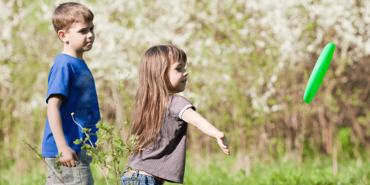 A picture of kids playing in the grass with no fear of ants