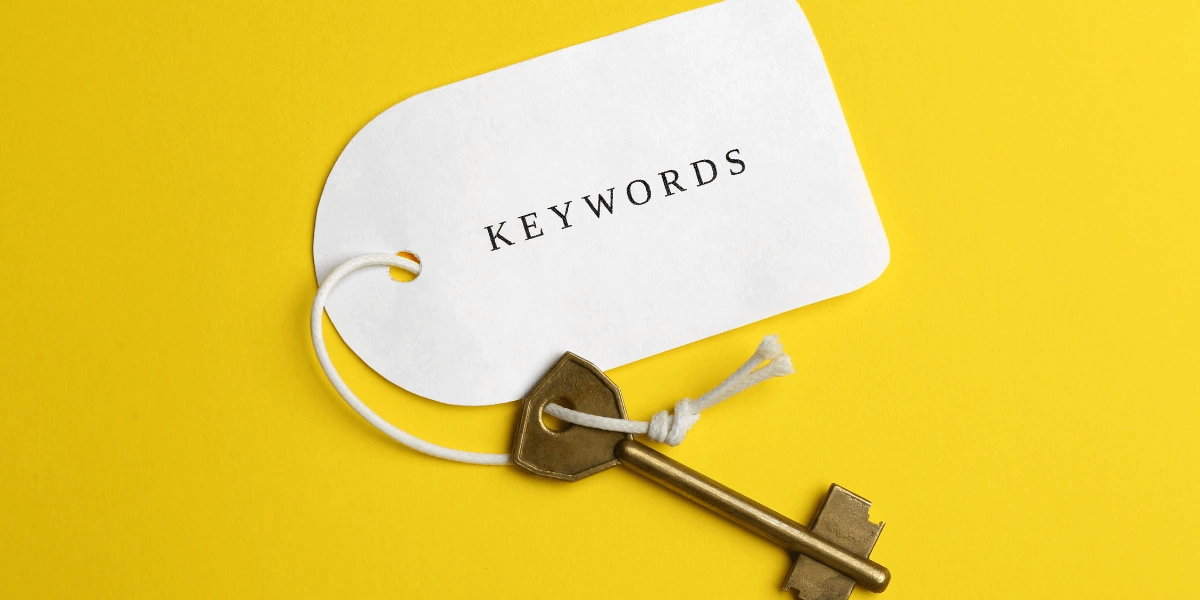 Key with a tag attached to it labeled 'Keywords' against a yellow background