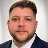 Professional headshot in navy suit.jpeg